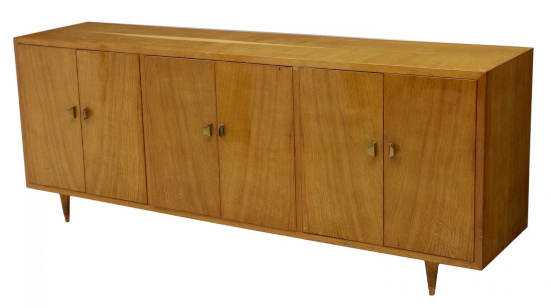 ITALIAN MID-CENTURY MODERN BIRCH FINISH SIDEBOARD: Italian mid-century modern birch finish sideboard, c. 1960, rectangular with one side fronted with six doors opening to shelved storage, the reverse side with open shelves and two doors, rising on squ