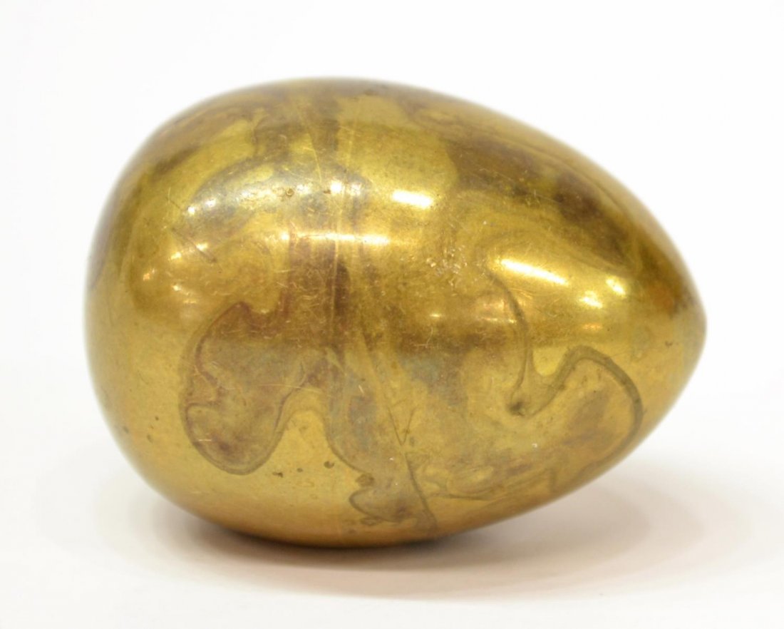 SMALL BRASS EGG PAPERWEIGHT, ATTRIB. CARL AUBOCK: Diminutive brass paperweight in the form of an egg, design attributed to Carl Aubock (Austrian, 1900â€“1957), .5"h, 1.5"l, .25lb Start Price: $50.00