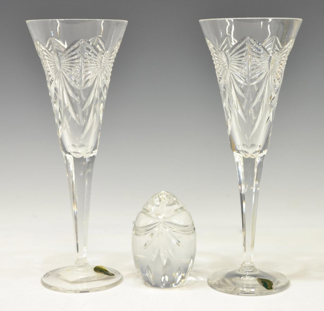 (3) WATERFORD MILLENIUM FLUTES & PAPERWEIGHT: (pair) Waterford cut crystal toasting flutes, from the Millenium Collection, cut with bows, acid marked underfoot, retaining Waterford sticker, 9.25"h, 3.5"w; together with (1) paperweight in the form