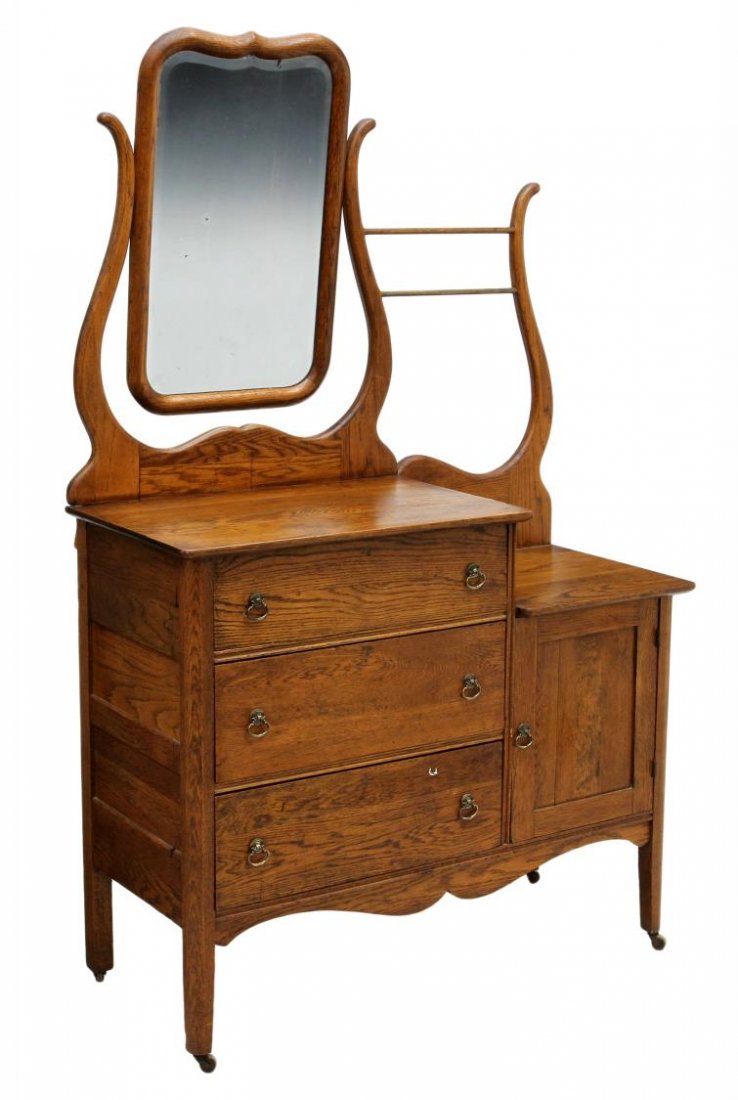 AMERICAN OAK HOTEL WASHSTAND: American golden oak hotel dresser washstand, c. 1910, the left side with tilting mirror above a dressing table top with three drawers, the right side a washstand with towel bar and lower door, rising 