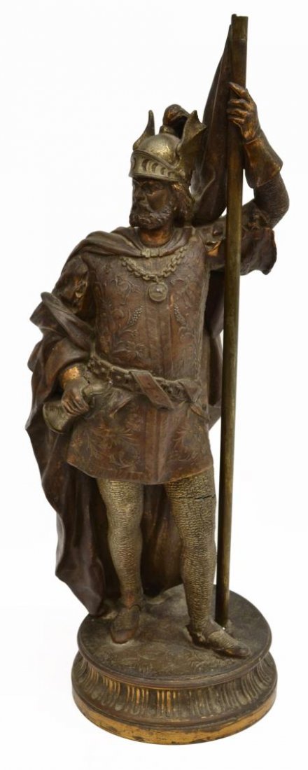 PARCEL GILT BRONZE STATUE OF A WARRIOR: Parcel gilt bronze statue of a Viking, clad in formal armor and a heavy cloak, one hand holding a horn the other a flag, dents and damage to base, small split at right leg, hole at back on base sugges