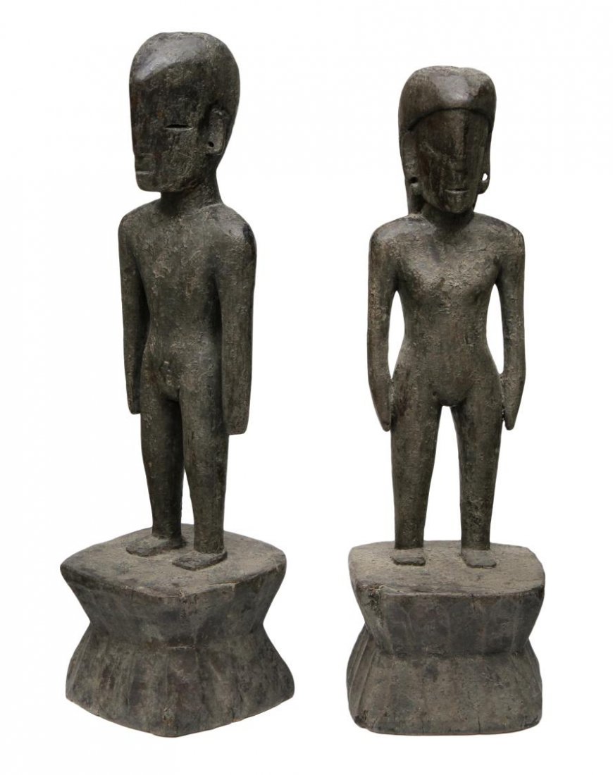 (2) ANTIQUE PRIMITIVE TRIBAL CARVED WOOD FIGURES: (lot of 2) Primitive tribal carved wood statues, possibly Ifugao, Philippine Bulul figures, male and female, each standing on a base, indentions to head, overall: 21"h, 10.25lb total Start Price: $150