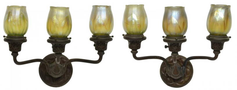 (PAIR) METAL WALL SCONCES WITH ART GLASS SHADES: (pair) Metal three-light wall sconces, a circular patterned back issuing three arms surmounted with lights and feather pulled iridescent art glass shades, shades acid signed various numbers, sconces w