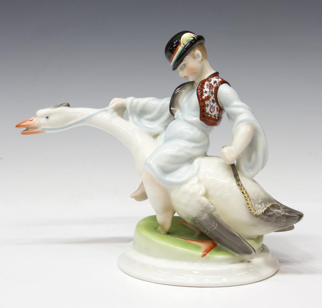 HEREND PORCELAIN FIGURAL GROUP, BOY & FLYING GOOSE: Herend porcelain figural group, Young Lad on Flying Goose, Hungary, the boy clad in a blue gown with bright polychrome vest and hat with feather, 8"h, 10"l, 2lbs Start Price: $50.00