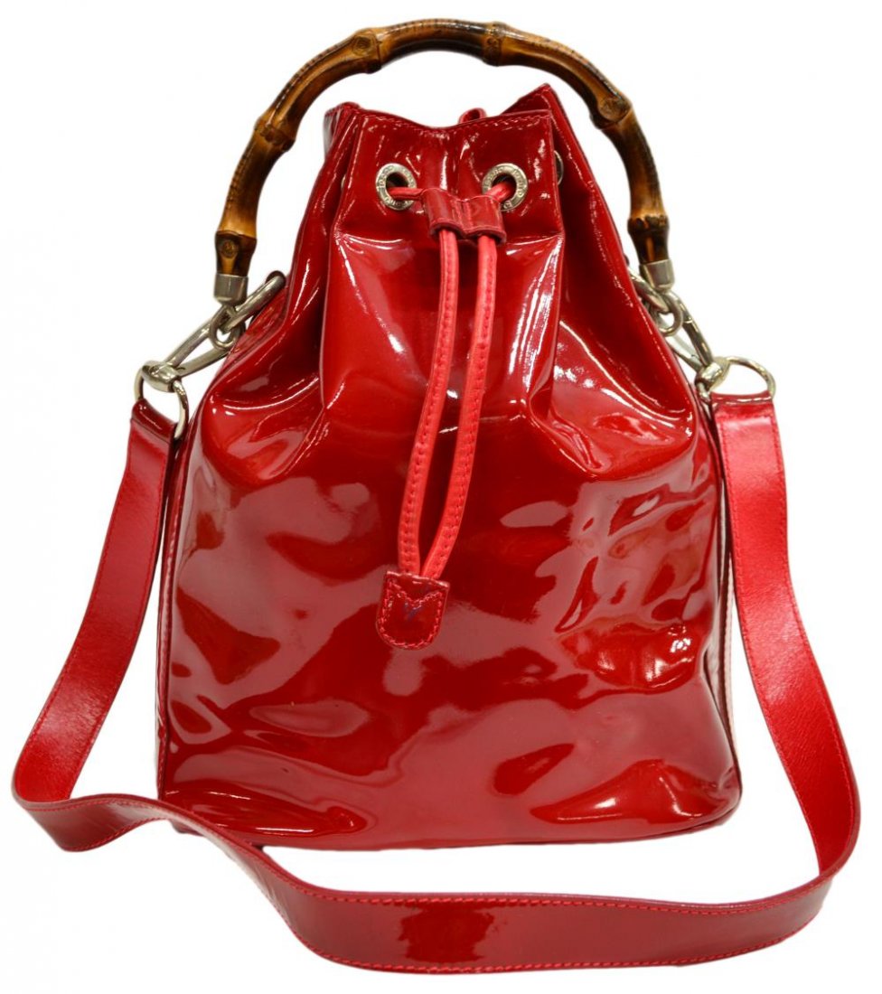 GUCCI RED PATENT LEATHER & BAMBOO DRAWSTRING BAG: Gucci red patent leather handbag with drawstring closure, bamboo handle and detachable red leather shoulder strap, tan interior with zippered compartment, accompanied by white Gucci dust bag, noticeab