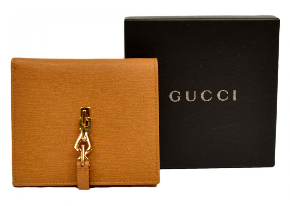 GUCCI SQUARE TAN & GILT METAL LEATHER WALLET: Gucci square tan leather wallet with gold toned hardware clasp opening to card and bill holder, 10 slots for cards, two for bills, coin storage on opposite side with snap closure, box included, wallet