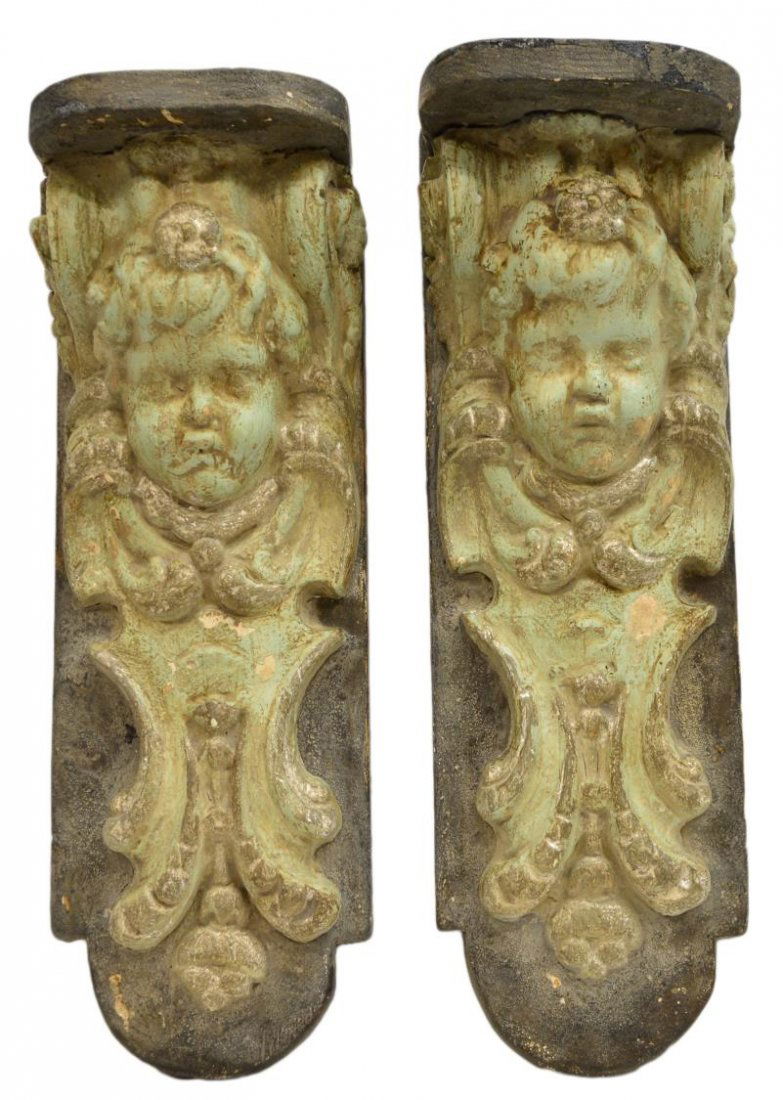 (2) ARCHITECTURAL CHERUB MASK WALL CORBEL SHELVES: (pair) Architectural hanging wall brackets, each wood shelf mounted with the plaster masque of a robust cherub, in light verde paint, some wear, loss, approx 23"h, 7.5"w, 20.5lbs total Start Price: $2