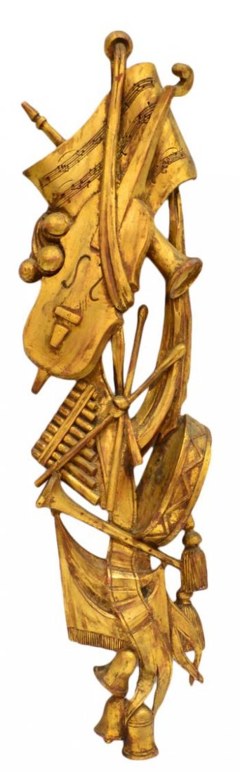 SPAIN GILDED MUSICAL CARVED ARCHITECTURAL ELEMENT: Carved parcel gilt wood architectural element, Spain, instruments intertwined with music sheets, ribbons, and tassels, remnants of red paint, restorations, 31.5"h, 8.5"w, 2.75lbs Start Price: $80.00