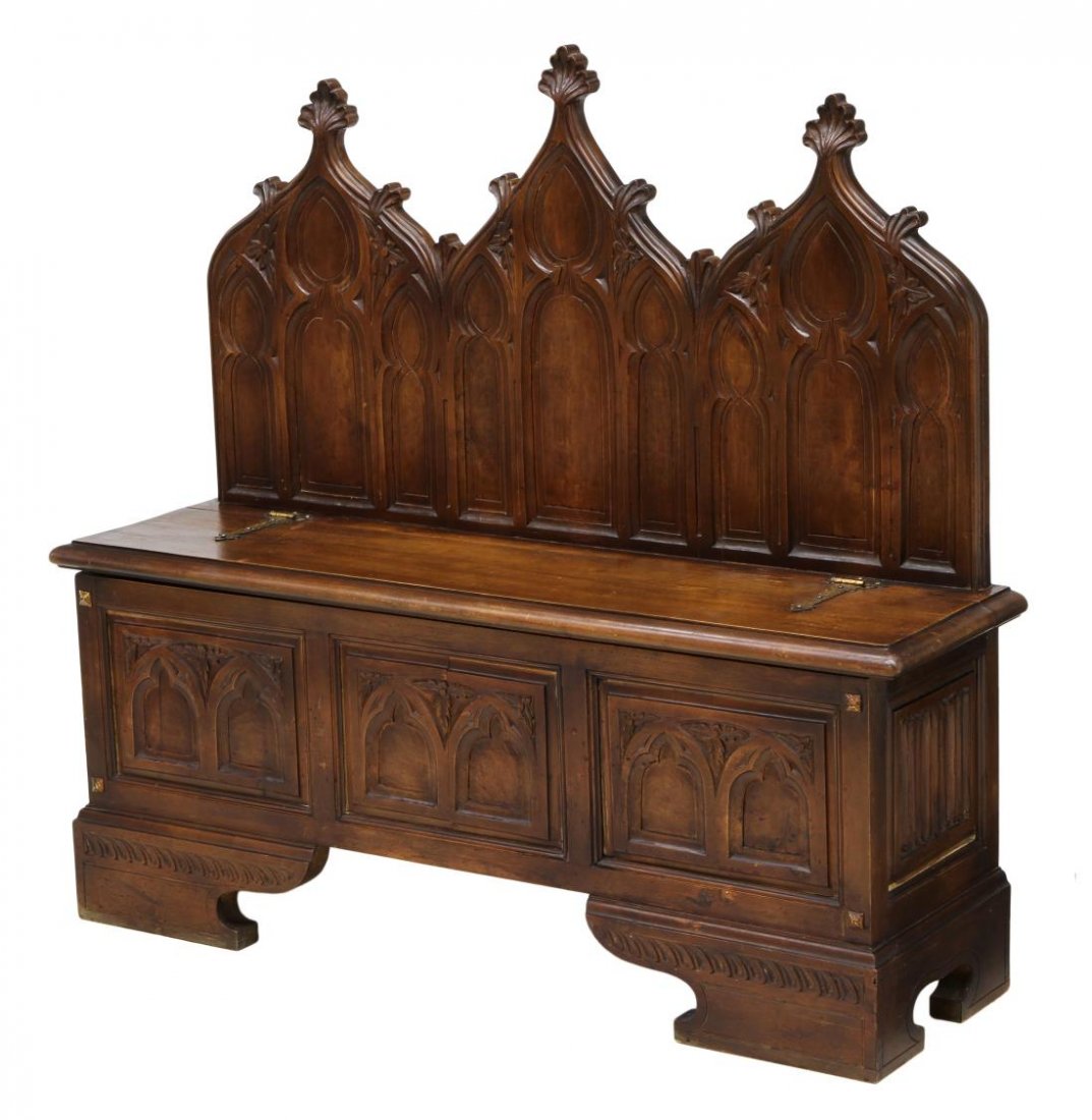 SPANISH GOTHIC STYLE HALL BENCH: Spanish walnut hall bench, Barcelona, early 20th c., the back with three gothic style spires over tracery, the seat with strap hinges opening to storage, raised on bracket feet, 45"h, 49"w, 13.5"d Sta