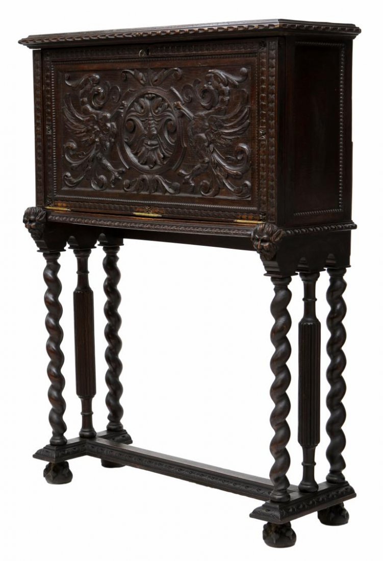 ANTIQUE SPANISH VARGUENO GRIFFIN CARVED CABINET: Spanish Renaissance style walnut vargueno or traveling desk on integral stand, 19th c. a stepped carved edge cornice over the drop front door with a carved central mask flanked by winged griffins, mas