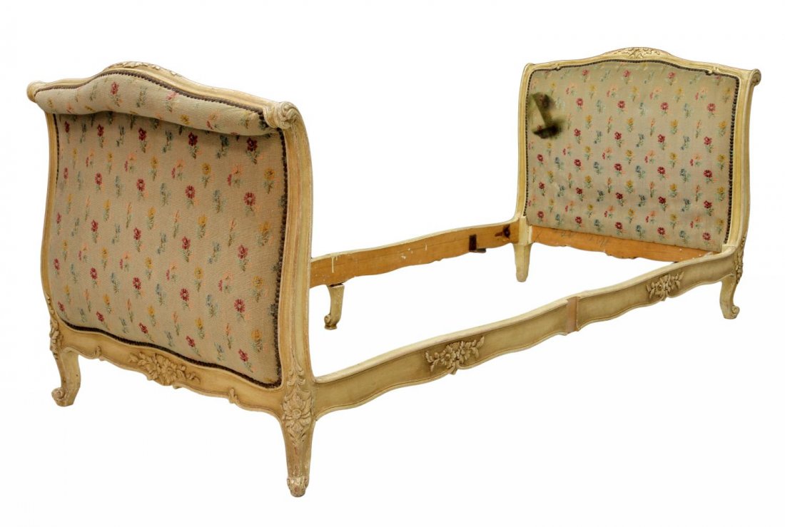 ANTIQUE FRENCH LOUIS XV STYLE DAY BED: French Louis XV style day bed in worn white paint, late 19th c. with foliate carved accents, remnants of the original coarse floral accented upholstery, rising on cabriole legs with scrolled feet, end