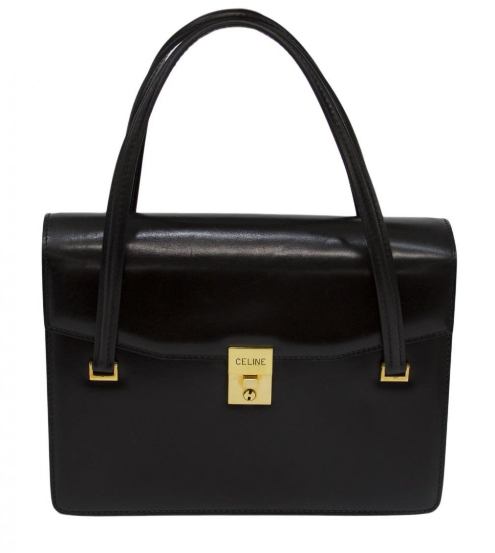 VINTAGE CELINE BLACK LEATHER HANDBAG: Vintage Celine handbag in black leather with gold tone hardware and key, black leather interior with three expandable compartments, two zipper pockets dividing the compartments, single side zipper com