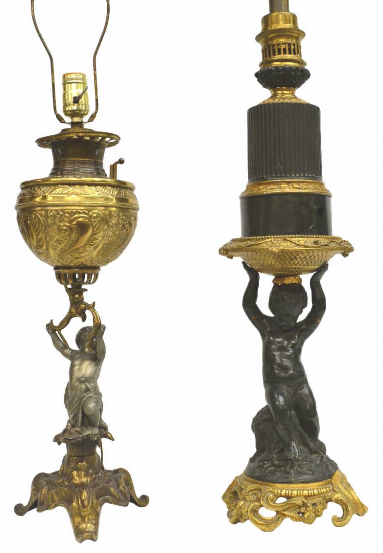(2) VICTORIAN & VINTAGE PARCEL GILT PUTTI LAMPS: (lot of 2) Victorian and vintage parcel gilt metal table lamps, each putti figure mounted on a gilt scrolling foliate designed base, one resting upon a ram, each holding gilded standards, (1) converte