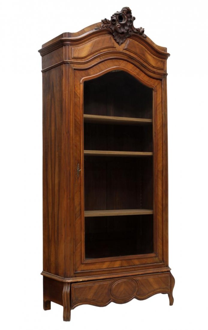 LOUIS XV STYLE WALNUT ARMOIRE LINEN PRESS: Louis XV style walnut armoire or press, c. 1900, having an arched pierce carved shell over a single clear glass door opening to adjustable height shelves, a lower drawers appearing as trim, raised on 