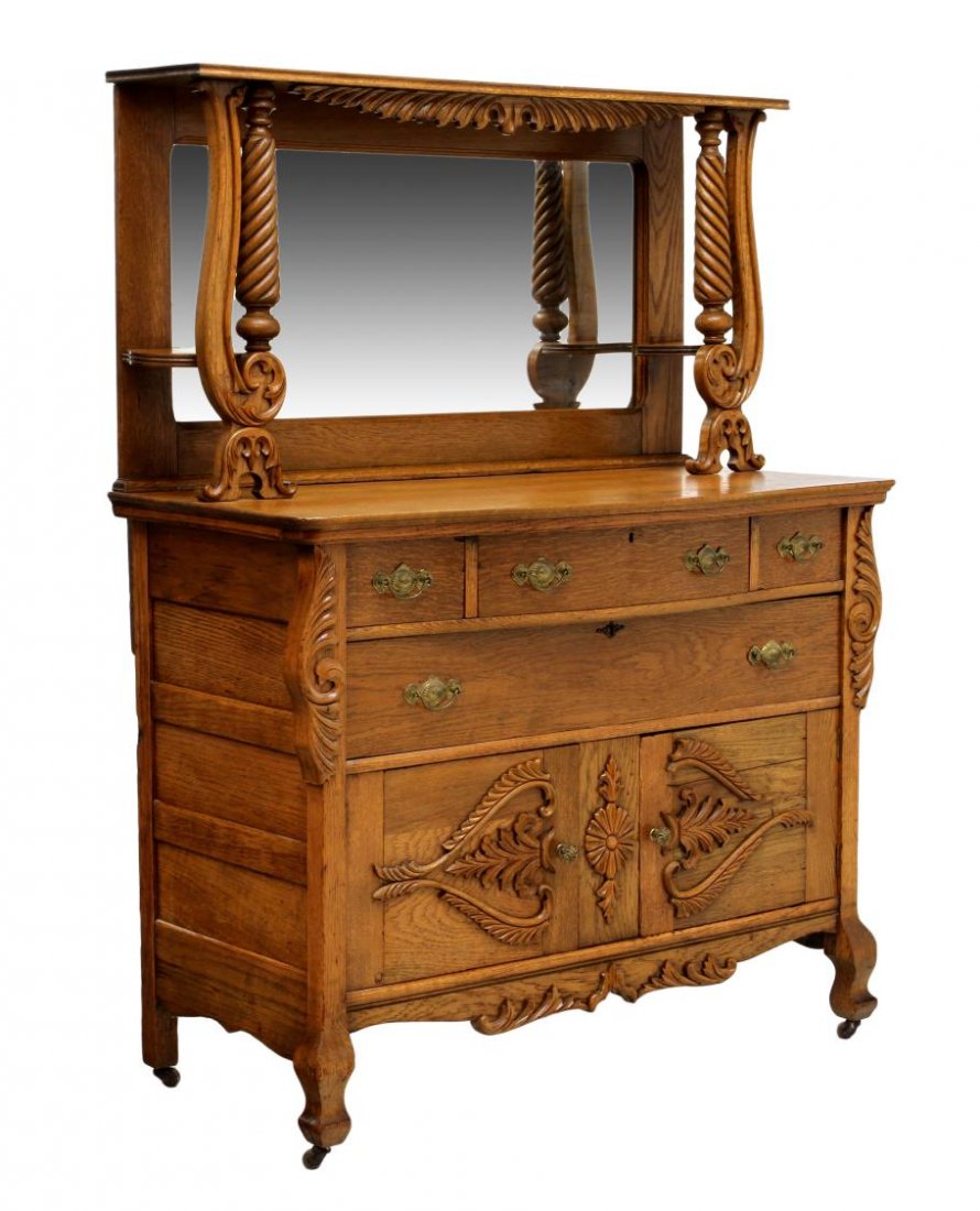 AMERICAN OAK MIRROR BACK SIDEBOARD: American oak sideboard, c. 1900, having a mirror back with scrolled and spiral supports, the bow top over three frieze drawers, a lower drawer above two doors, rising on shaped legs with castors, 64.2