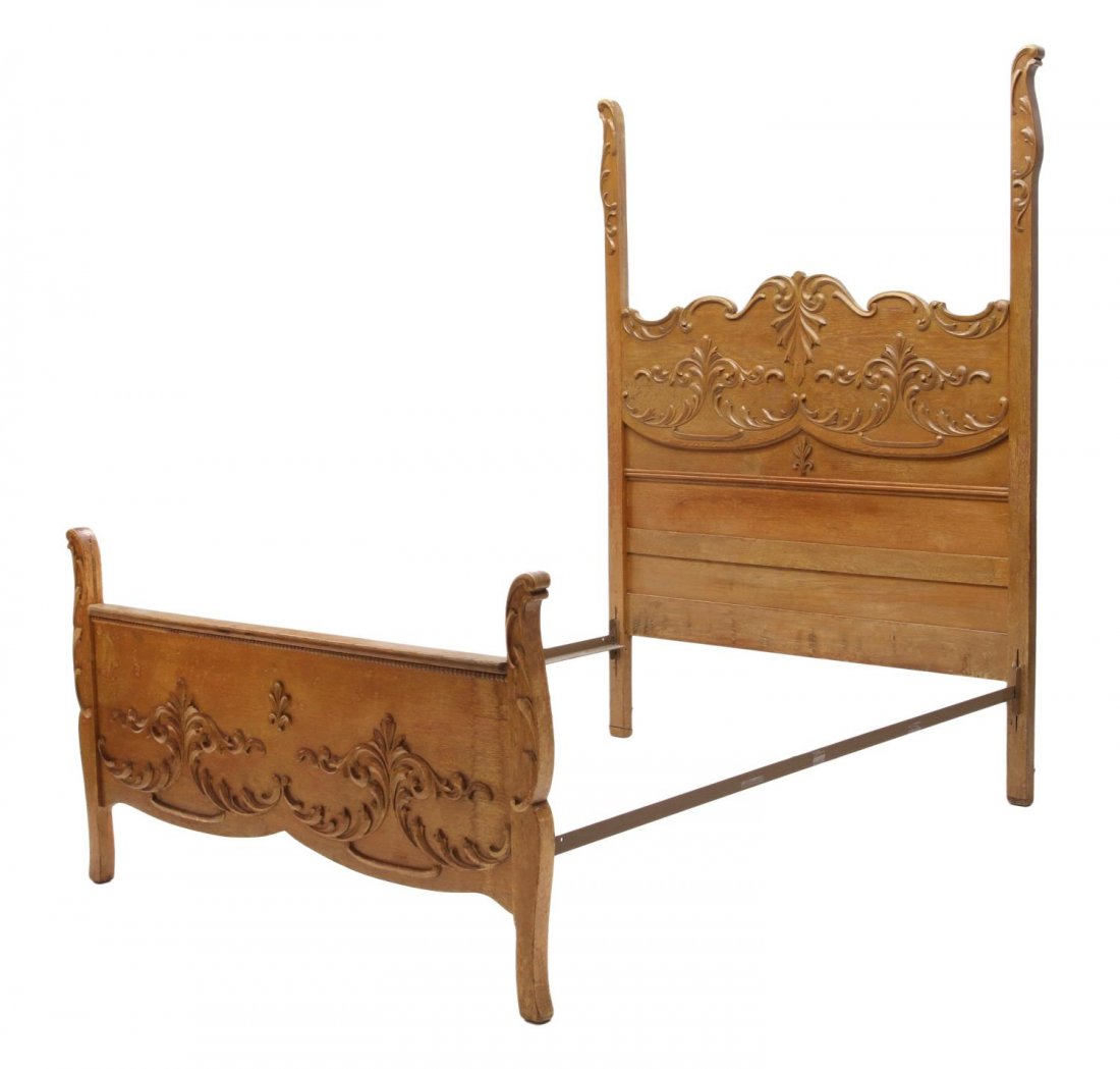 AMERICAN OAK BED, EARLY 20TH C.: American oak bed, early 20th c., the headboard with shaped posts, applied foliate carving, a conforming smaller foot board, later metal rails, headboard: 78"h, 57"w, inside: 54.5"w, 75.5"l Start Price