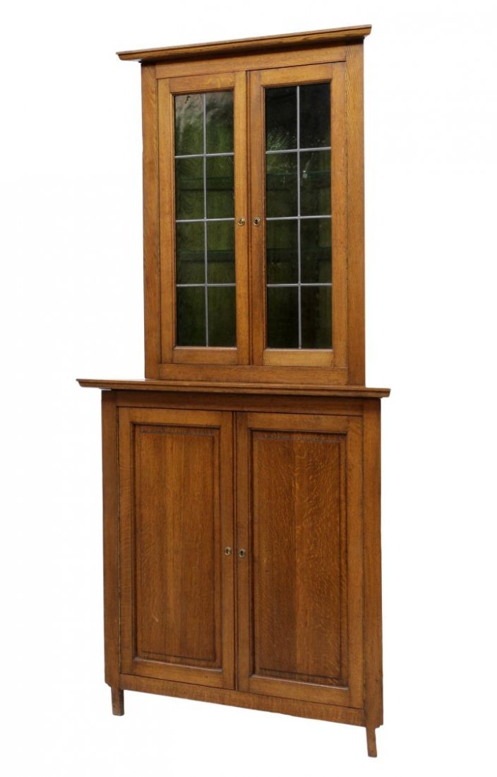BELGIUM LEADED GLASS CORNER CABINET: Oak corner cabinet, Belgium, 20th c., the stepped cornice over two doors with green leaded glass opening to adjustable height glass shelves, the lower cabinet with two doors opening to wood shelves, r