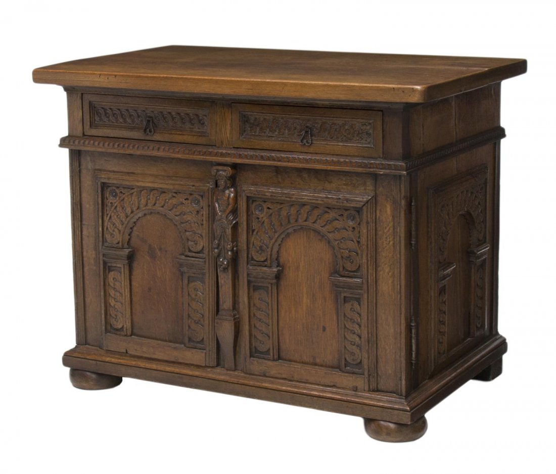 19TH C. GOTHIC STYLE FIGURAL CARVED OAK CABINET: Gothic style figural carved oak cabinet, 19th c., the thick, overhang top, over the case having carved arches and central demi-figure, fitted with two drawers and cabinet doors, opening to a later whi