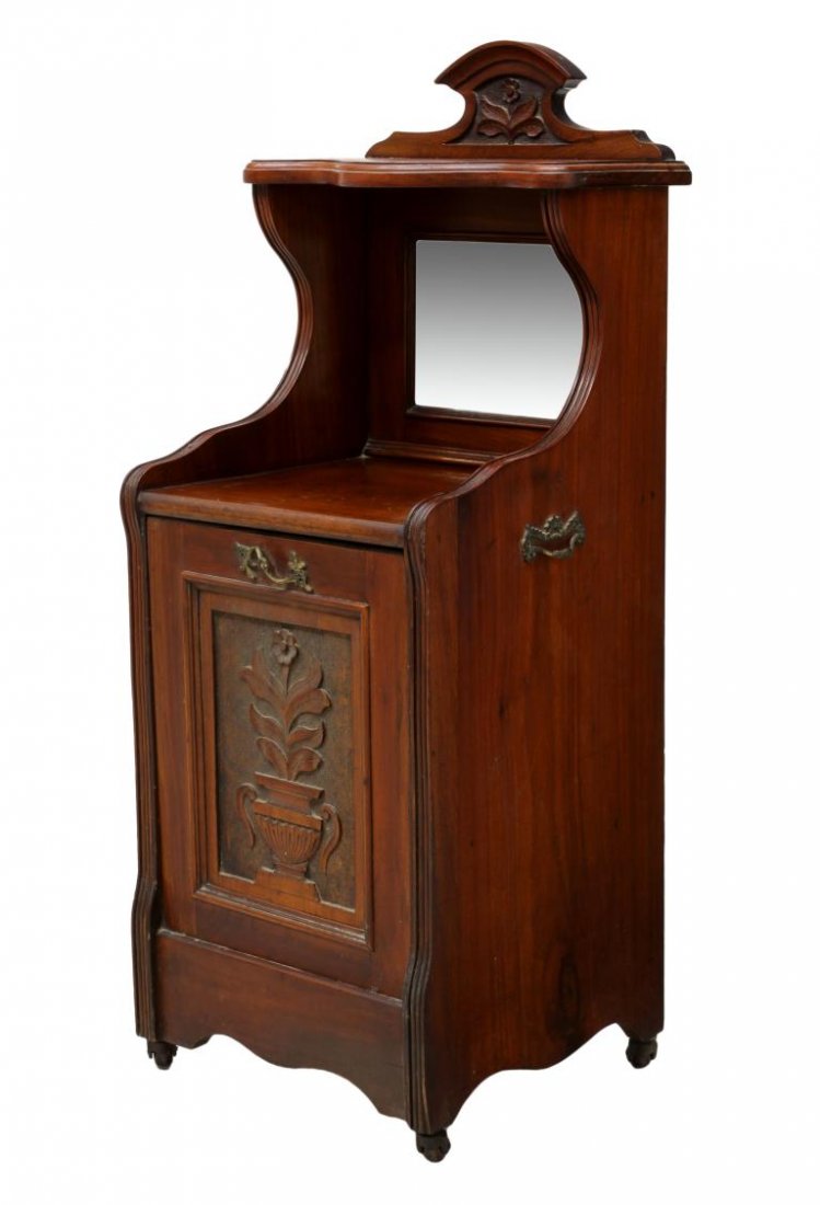 ENGLISH MIRRORED COAL BOX CABINET: British mahogany finish coal box, c. 1900, having a shaped crest, a display shelf set over a beveled mirror, the cabinet front with floral carving opening to a coal storage area, all with metal insert