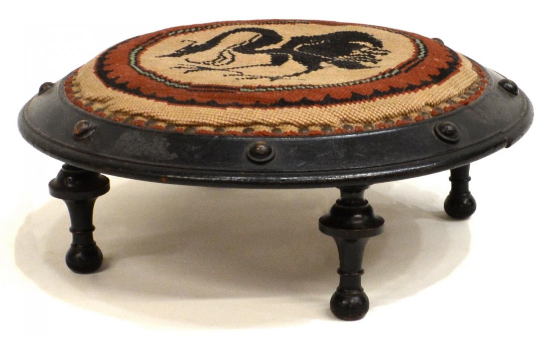 ANTIQUE WINGED GRIFFIN NEEDLEPOINT FOOT STOOL: Antique foot stool, the circular top having needlepoint cover with central winged griffin, rising on turned legs, 5"h, 13.25"w, 3.25lbs *Provenance: From the estate of Don Yarton (Ohio, Texas, 1941-20