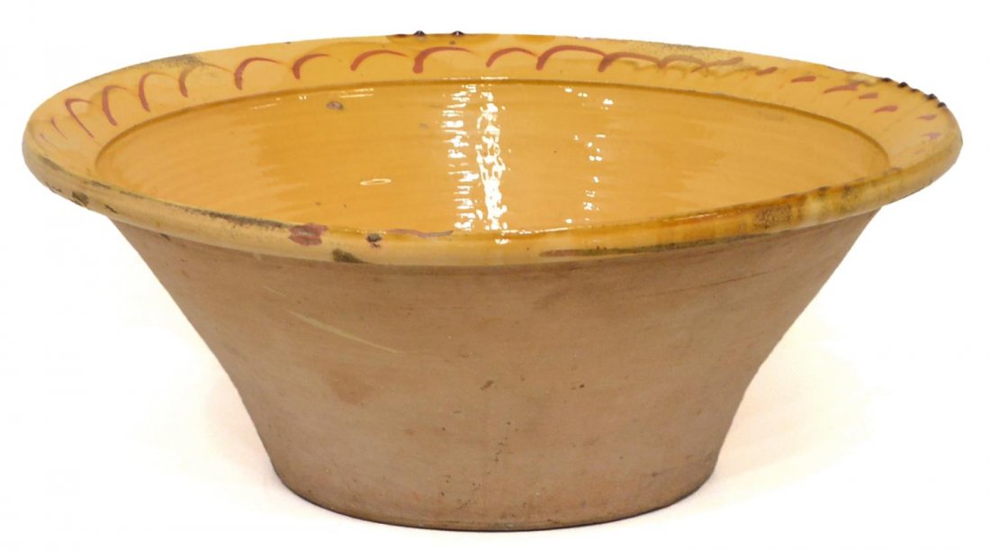 LARGE ANTIQUE SPAIN GLAZED POTTERY BASIN: Large earthenware bowl, Spain, early 20th c., yellowish glazed interior with stylized accent on rim, unglazed exterior, intact hairlines, some chipping, 9.75"h, 25"diam *Provenance: From the estate of