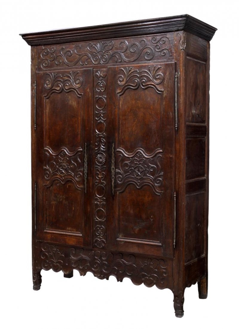 FRENCH LOUIS XV PROVINCIAL ARMOIRE, 18TH C.: French Louis XV provincial oak armoire, 18th c., having a stepped cornice over the frieze, two doors opening to a shelf and drawers, and skirt decorated with relief foliate carving, each door panel wi