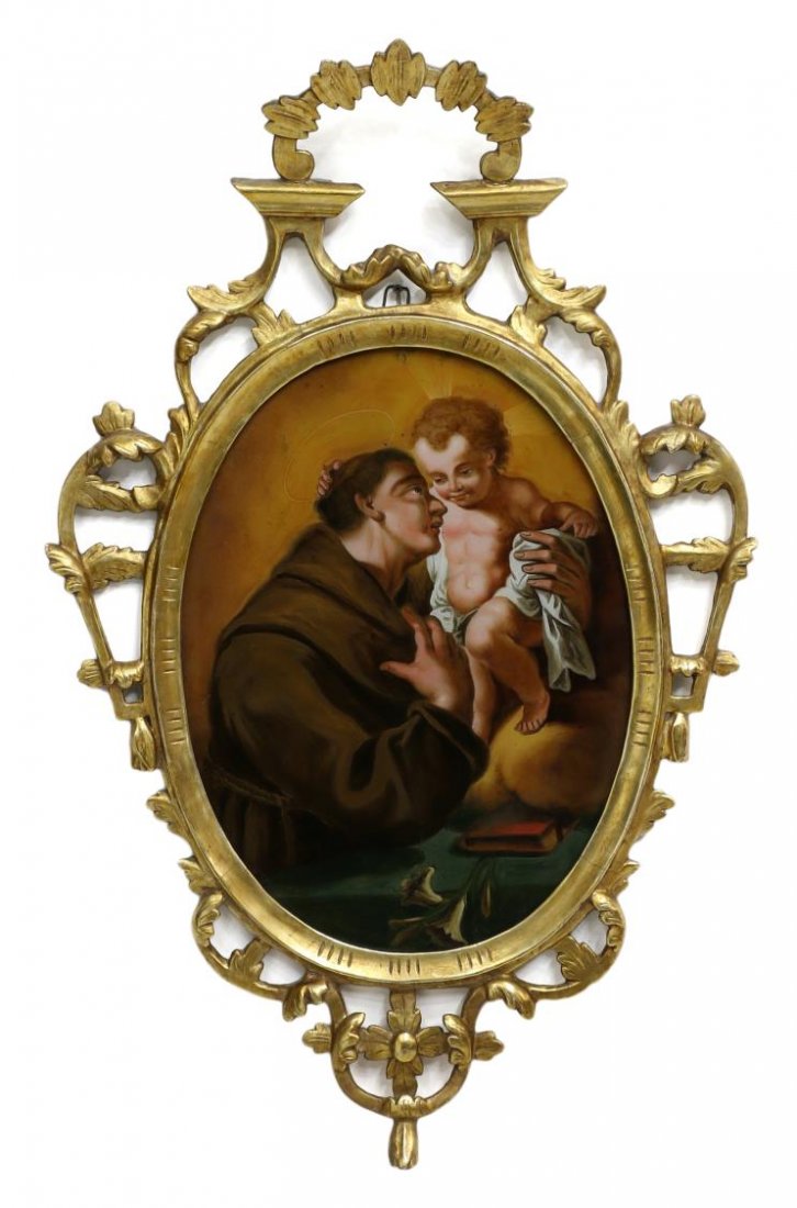 ANTIQUE SPAIN RELIGIOUS REVERSE PAINTING, GILT: Northern Spain religious reverse painting on glass depicting a male saint with a child, likely Saint Anthony of Padua, enclosed by an arched, gilded wood and gesso frame carved with open work foliate 