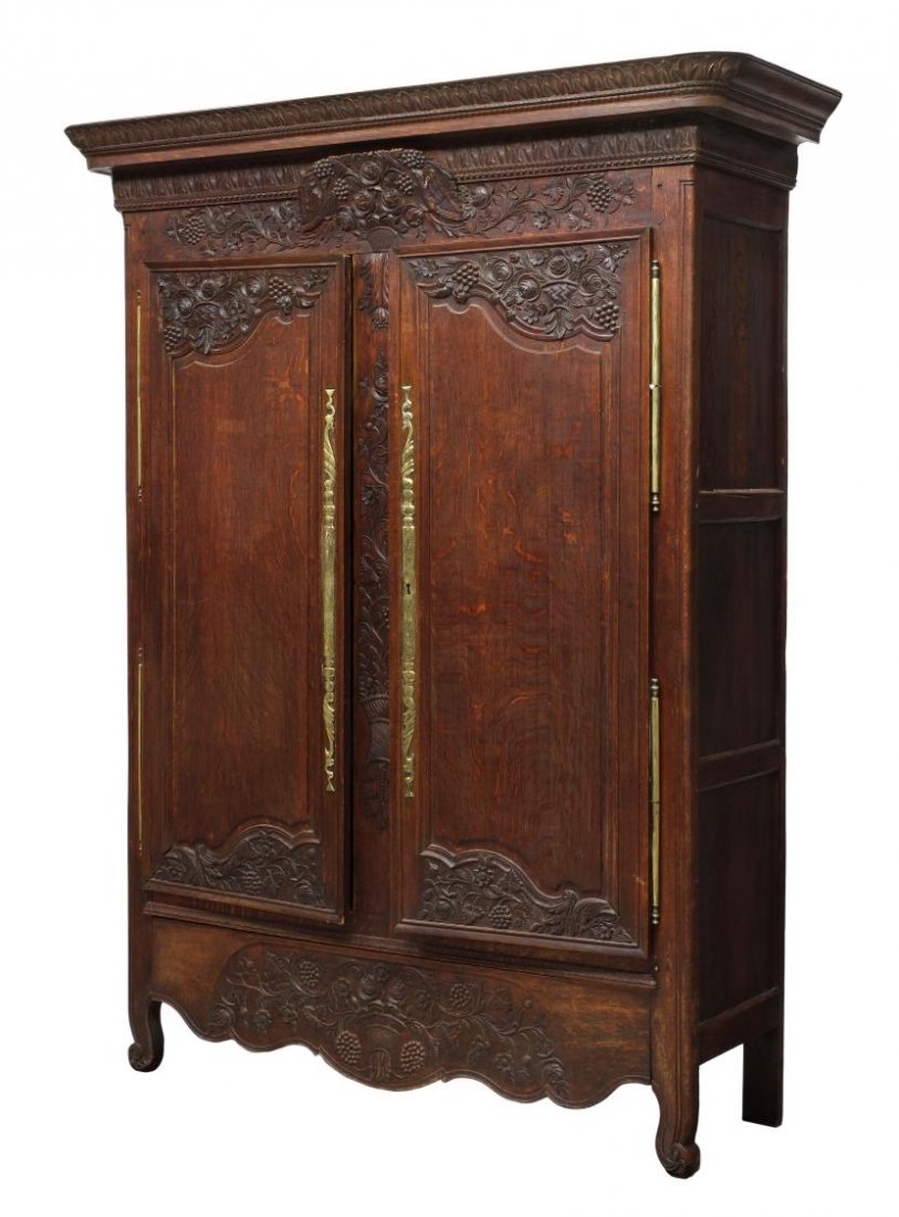 FRENCH PROVINCIAL MARRIAGE ARMOIRE, 18TH C.: Louis XV provincial oak armoire, 18th c., having extensive carving at the stepped cornice, frieze, doors and skirt, a cartouche with carved love birds at upper center, two doors with long brass hinges
