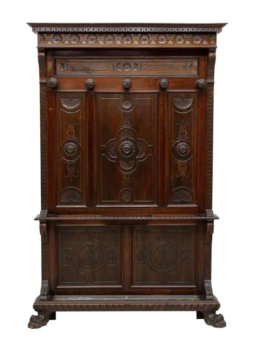 RENAISSANCE REVIVAL WALL HALL TREE: Italian Renaissance Revival wall hall tree, c. 1900, a stepped cornice over dentil and geometric carving, five coat hooks at the three panel back with foliate carving, a central bar with umbrella rack