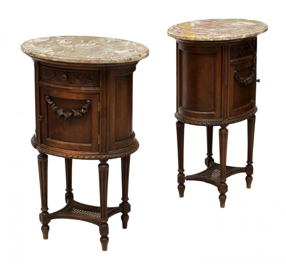 (2) FRENCH LOUIS XVI STYLE MARBLE TOP NIGHTSTANDS: (lot of 2) French Louis XVI style oval form bedside cabinets, 19th c., having a marble top over a single drawer, a lower door with floral garland carving, raised on tapered ribbed legs joined by a low