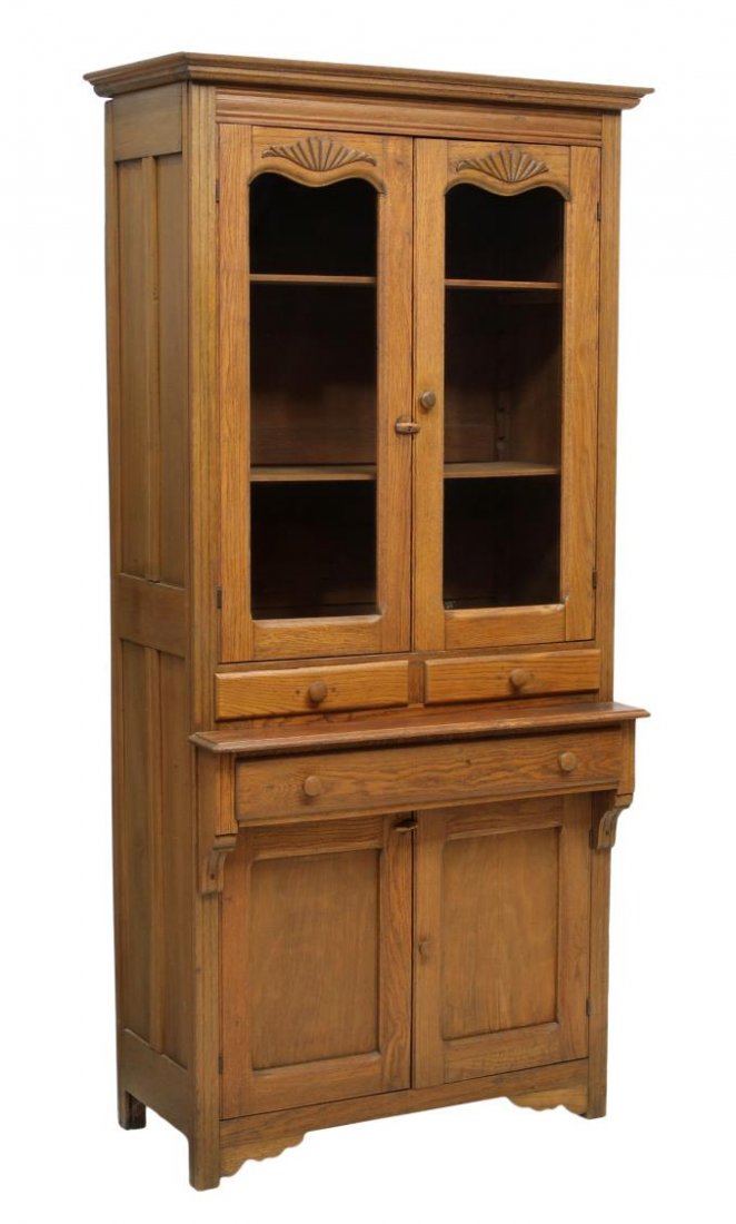 ANTIQUE AMERICAN OAK CUPBOARD WITH GLAZED DOORS: American oak stepback cupboard, c. 1900, a protruding cornice over two glass doors, two short center drawers, a long drawer and two lower drawers, rising on block feet with scalloped brackets, 82"h, 3