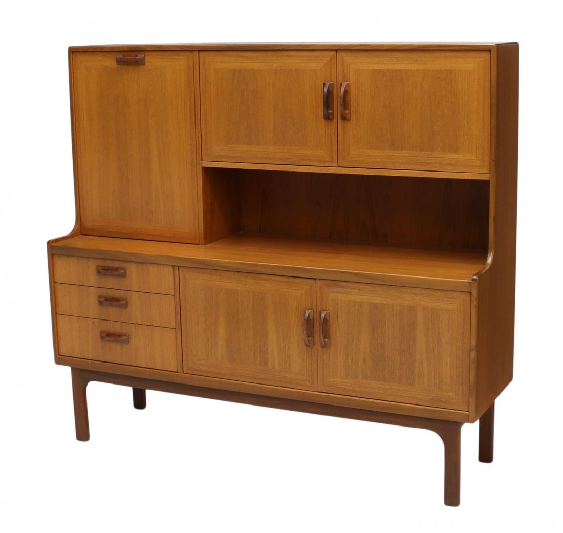 MID-CENTURY MODERN TEAKWOOD SIDEBOARD SERVER: Mid-century modern teakwood sideboard, the upper case having a fall front door and cabinet doors, all opening to storage, the base set with three drawers and cabinet doors, the upper most drawer divid