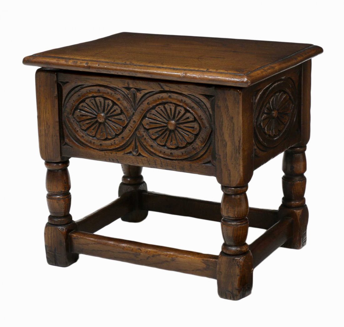 DIMINUTIVE OAK HINGED TOP STOOL: Antique style oak stool, late 20th c., a rectangular top opening to storage over the foliate carved frieze, rising on stretcher joined turned legs with block feet, 15"h, 17"w, 13"d