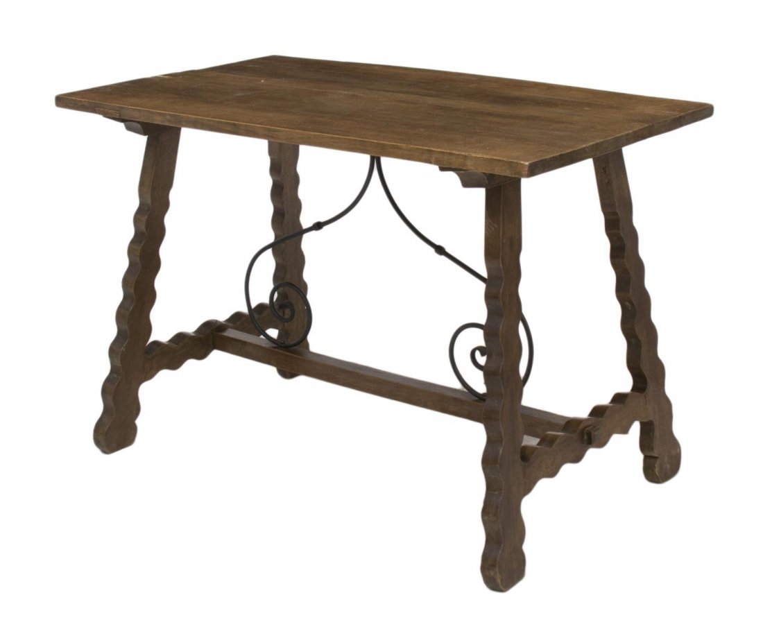 SPANISH BAROQUE STYLE CARVED WOOD & IRON TABLE: Spanish Baroque style library or hall table, 19th c., the plank top rising on carved trestle supports, joined by iron stretchers, old beetle holes, approx 29.25"h, 43.25"w, 25"d Start Price: $200.00