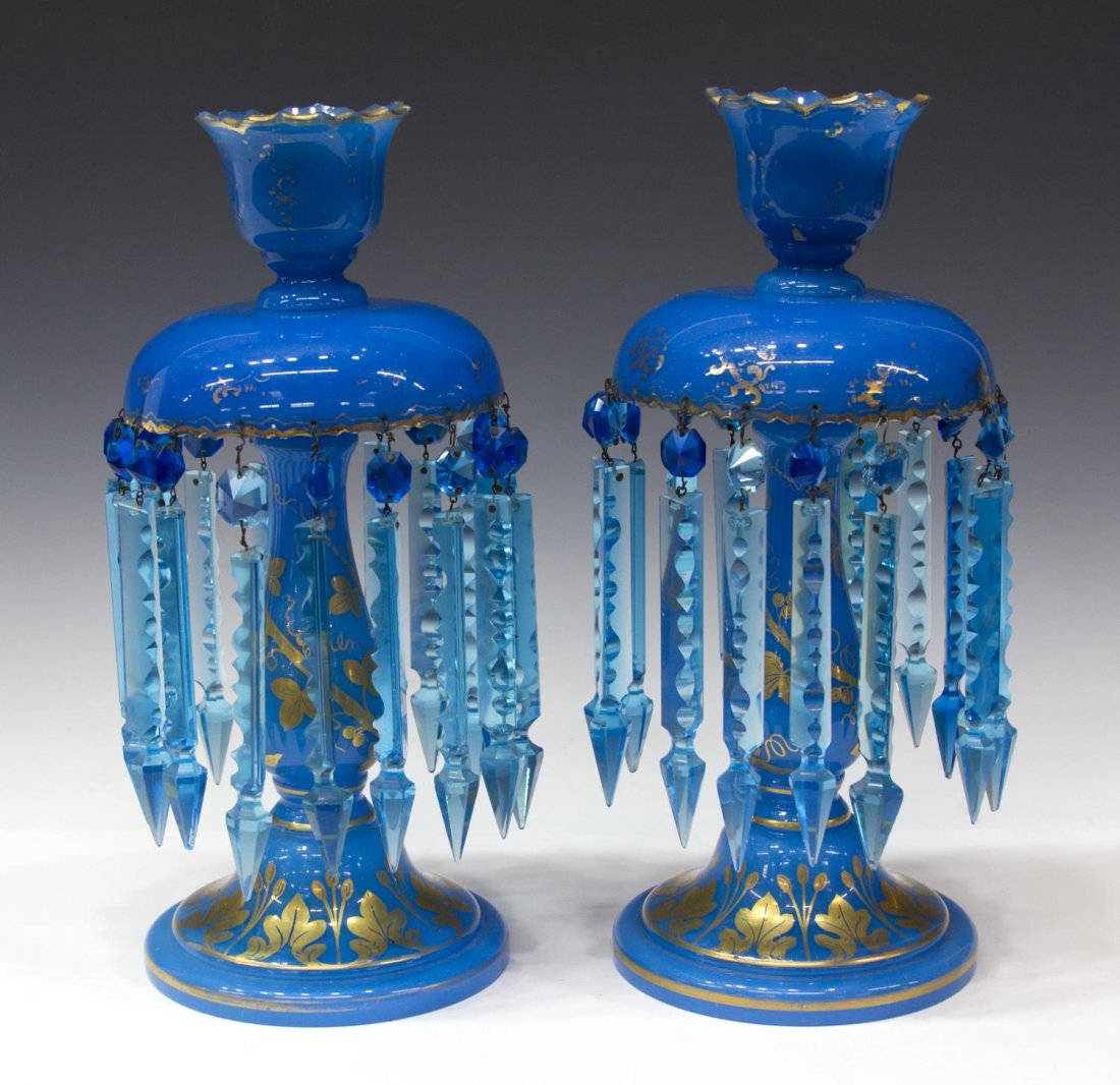 (2)ANTIQUE PARCEL GILT BLUE OPALINE MANTLE LUSTRES: (pair) Continental parcel gilt opaline glass mantle lustres, retaining one enamel and paint decorated hurricane shade, reserved to one side is a heraldic lion, each candle cup surmounting a standard d