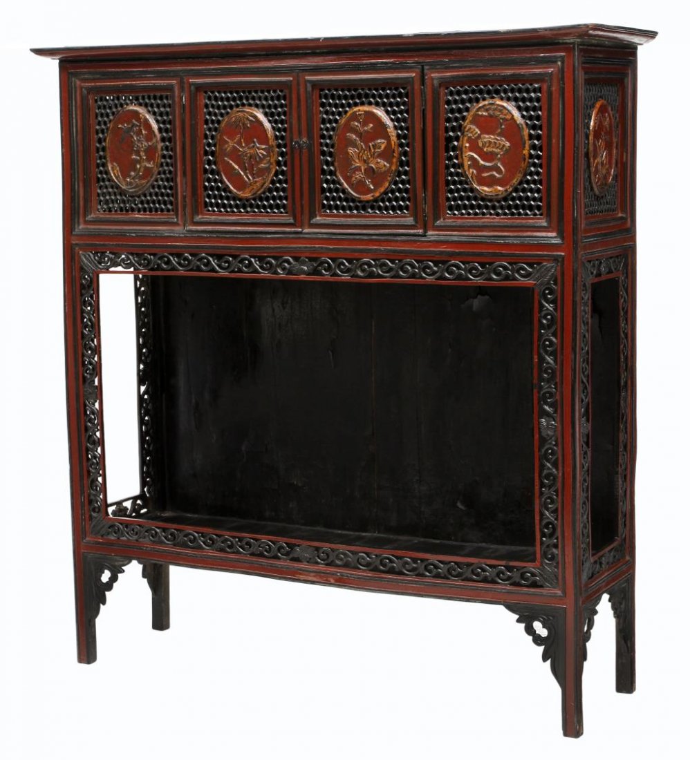 FRENCH COLONIAL PIERCE CARVED OPEN CABINET: French Colonial red painted parcel gilt display cabinet with black painted accents, early 20th c., having a stepped cornice over pierce carved panels including two doors, the lower open section framed