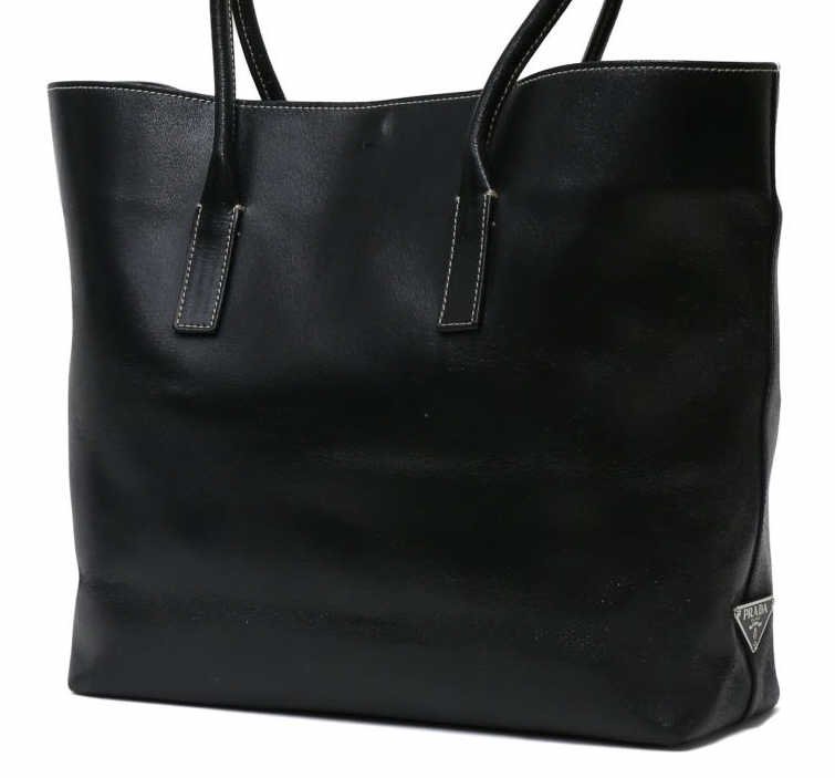 PRADA BLACK LEATHER TOTE BAG / HANDBAG: Prada black leather tote, tie closure, small interior zipped accessory bag, side logo , slight wear, bag: approx 10"h, 14.5"l, Start Price: $60.00