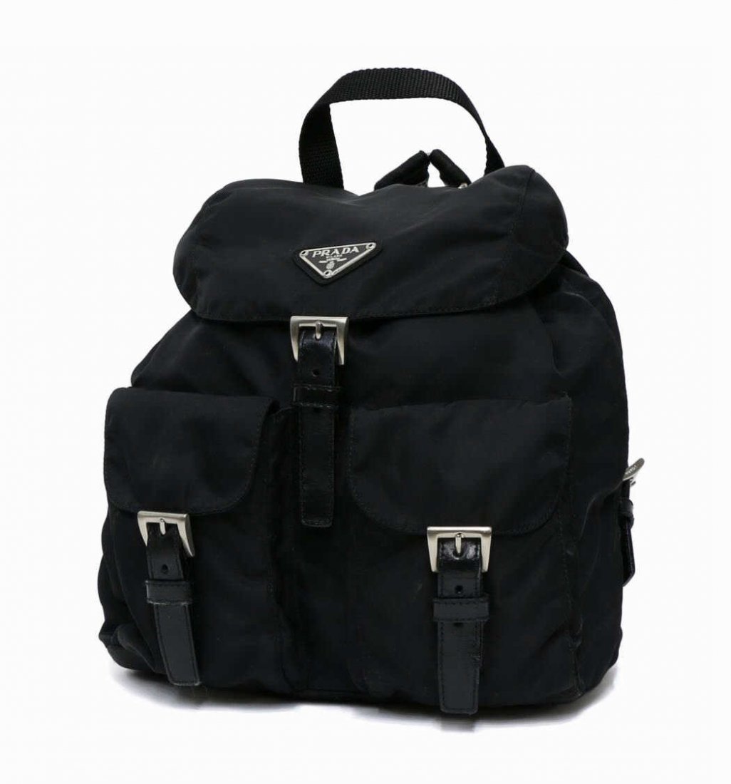 PRADA BLACK NYLON DRAWSTRING POCKET BACKPACK: Prada black nylon backpack, dual exterior pockets, fold over and drawstring closure, zipped pocket on lined logo interior, old dust bag, approx 11"h, 9"w, 1lb Start Price: $100.00