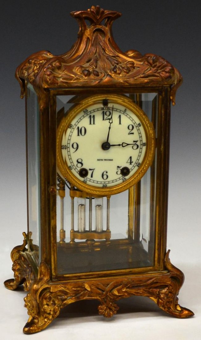 SETH THOMAS ART NOUVEAU BRONZE & GLASS CLOCK: Seth Thomas Art Nouveau parcel gilt bronze and beveled glass cased clock, porcelain face with Arabic numerals, time and strike works with mercury pendulum, operates starting and stopping, 14"h, 8"w, 6