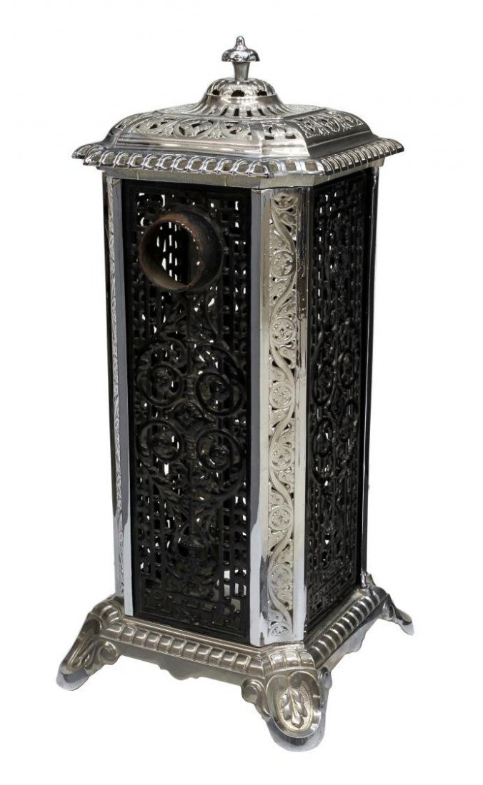 DECORATIVE CHROME PLATED ANTIQUE WOOD STOVE: Decorative wood stove frame, c. 1900, having profuse foliate decoration, the top, side supports and base with shiny chrome plating, the pierced side panels in black, 36.25"h, 17"w, 17"d Start Price: $