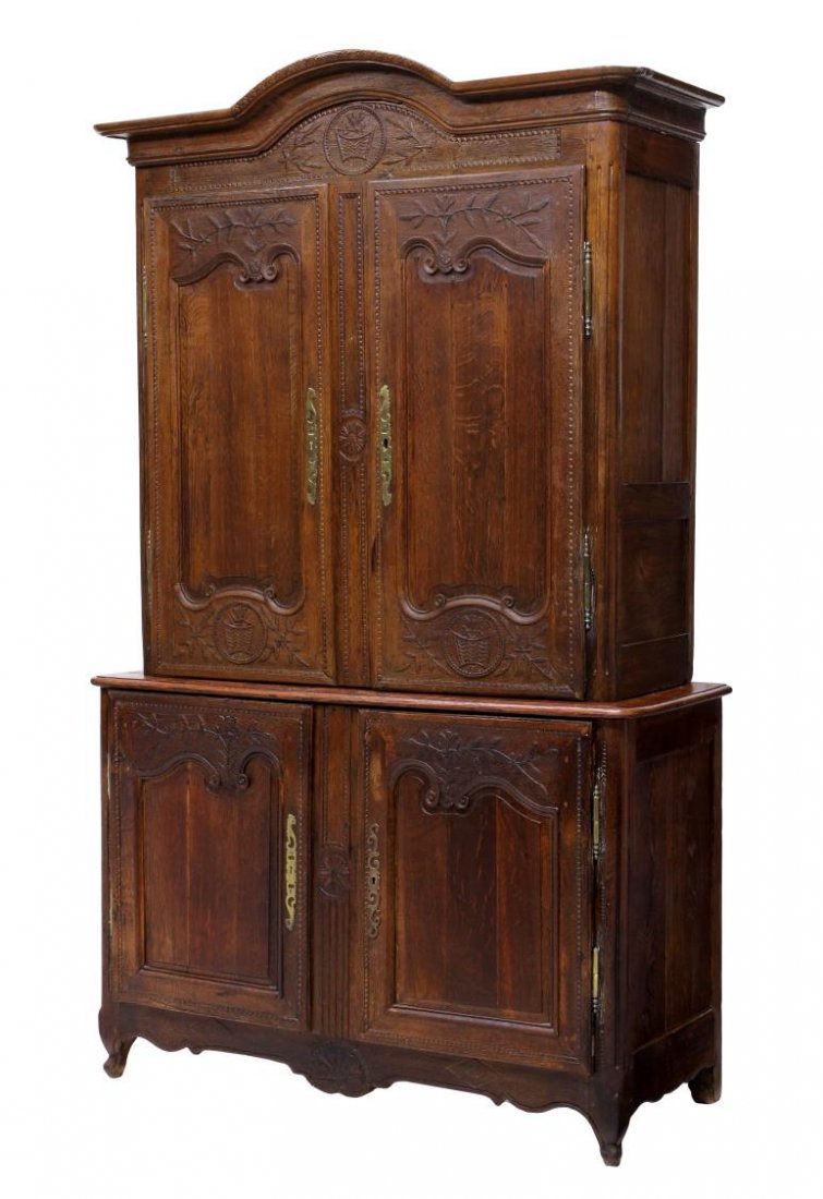 FRENCH OAK DEUX CORPS 18TH C. CABINET: French Louis XV oak deux corps cabinet, 18th c., decorated with relief carved foliage, vases and florals, the upper cabinet with arched cornice with later date over two doors, the lower cabinet with t