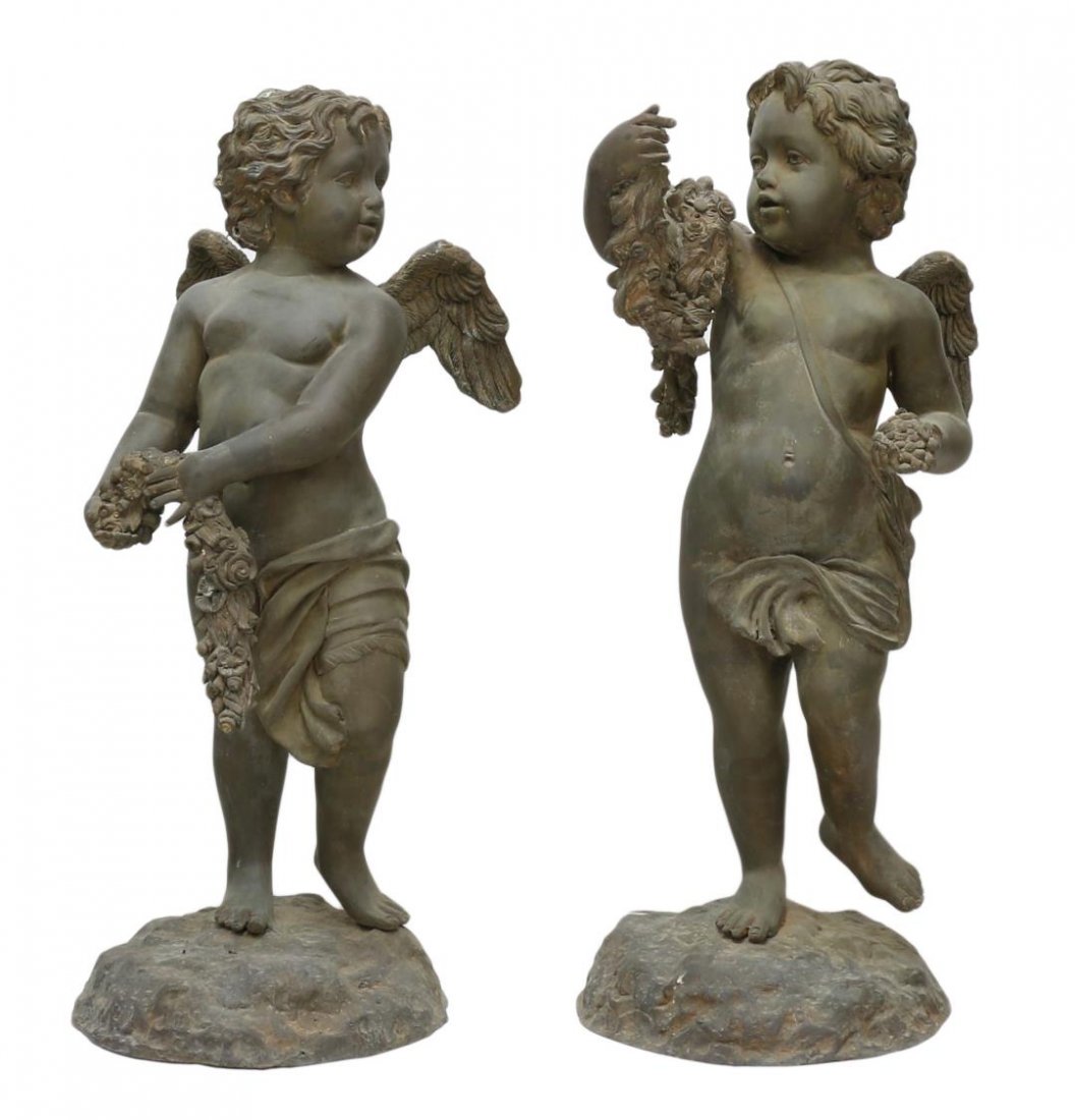 (2) LARGE PATINATED BRONZE CHERUB GARDEN FIGURES: (pair) Large verde patinated bronze garden statuary, each a robust winged cherub holding floral garland and standing upon a naturalistic base, weathered outdoor patination, approx 35"h Start Price: $5
