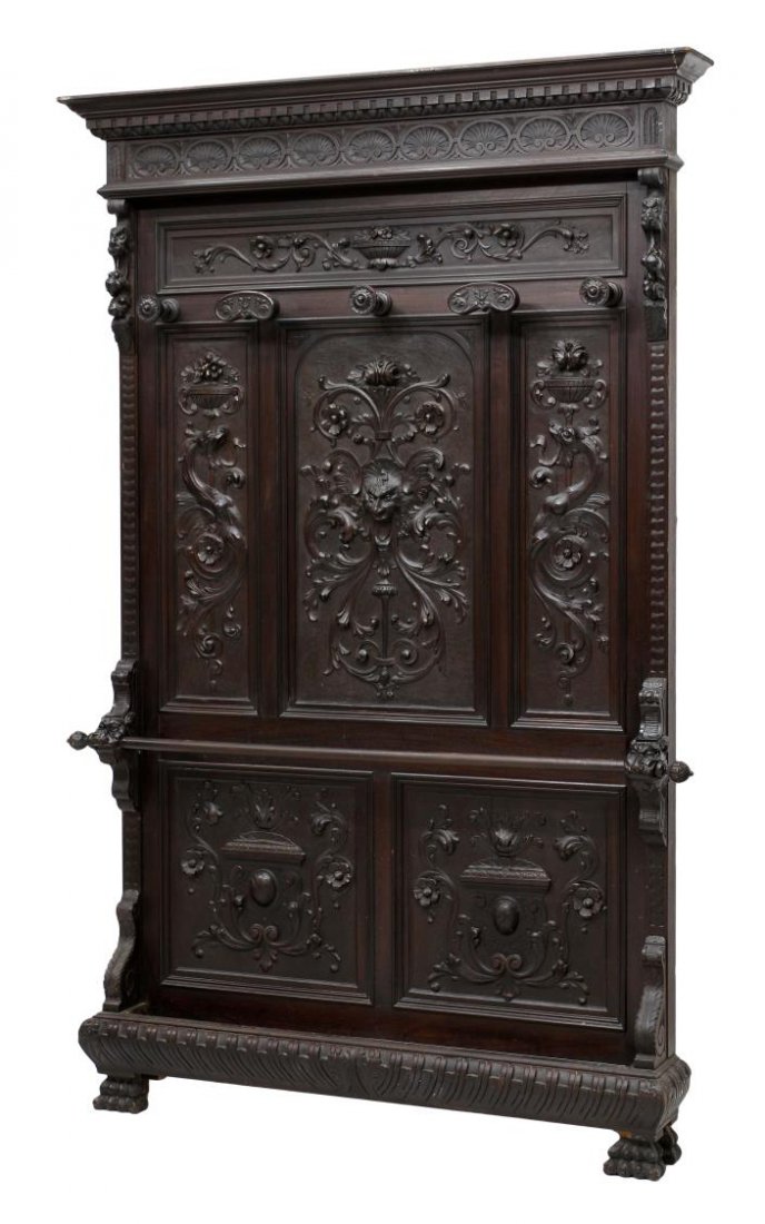 ITALIAN RENAISSANCE REVIVAL EBOINZED HALL TREE: Italian Renaissance Revival ebonized hall tree with mask, foliate and griffin decoration, the protruding cornice with carved shell frieze over five coat hooks, a lower protruding umbrella rod held by 