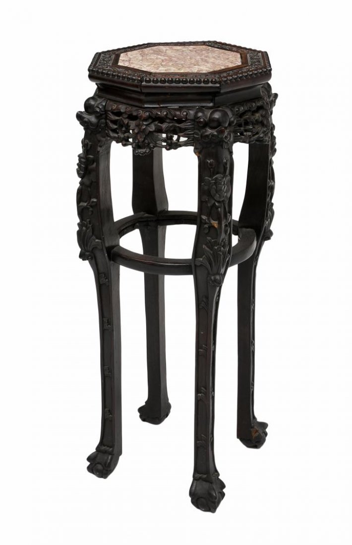 CHINESE PIERCE CARVED MARBLE TOP PLANTSTAND: Chinese hardwood plant stand, early 20th c., decorated with relief foliate carving, an octagonal top with inset marble over the pierced frieze, all rising on ball and claw foot squared legs joined by