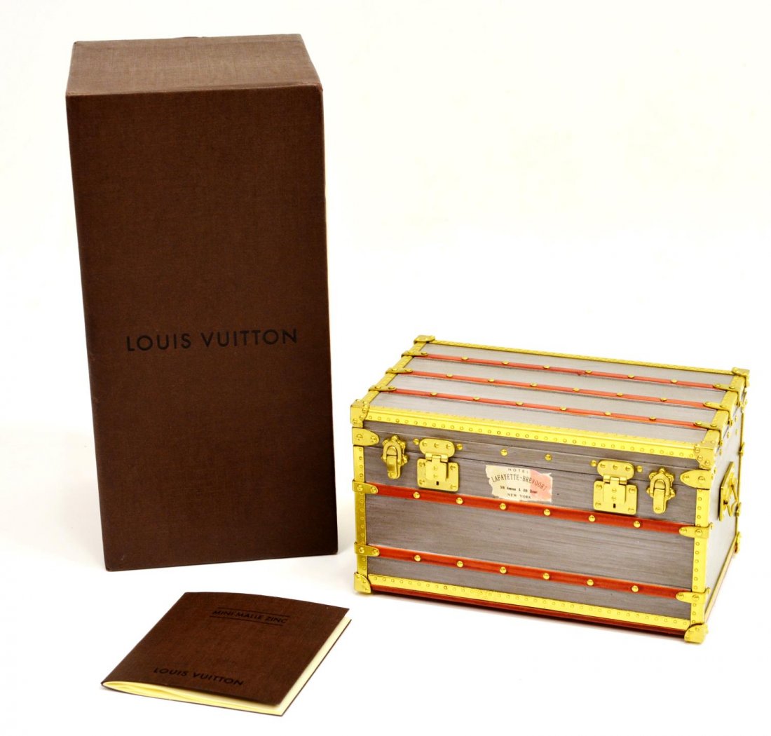 LOUIS VUITTON MINI MALLE TRUNK PAPERWEIGHT IN BOX: Louis Vuitton "Mini Malle Zinc" paperweight, in the form of a travel trunk, retaining original box (slightly worn) and care booklet, trunk: 2.75"h, 4.5"l, 2.75"w, 1lb