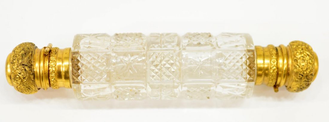 VICTORIAN CUT GLASS & REPOUSSE GILT METAL PERFUME: Victorian cut glass lay down scent bottle, dual sections, each having repousse gilt metal cap, the cut body alternating diamond and sunburst cut squares, concealing interior glass stopper, 4.75"l, .25