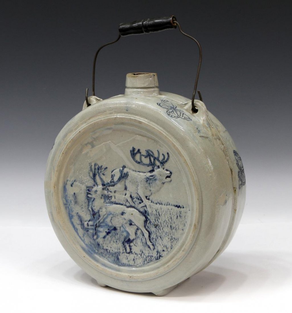 AMERICAN STONEWARE STAG IN RELIEF CANTEEN: American salt glaze stoneware canteen, possibly Whites Utica Pottery, New York, depicting grazing moose or deer in a mountainous pasture, butterflies featured on sides, cobalt blue accents, wire and w