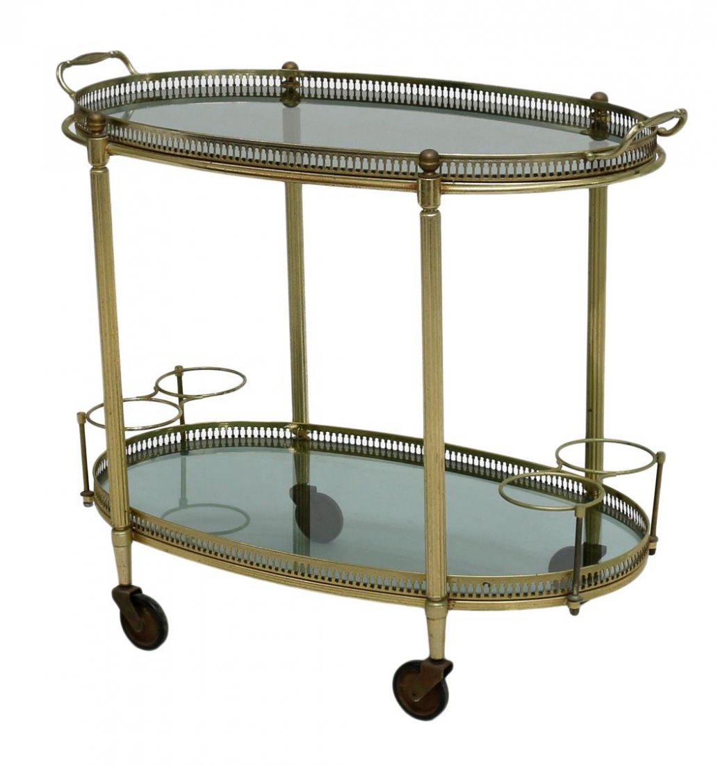 ITALIAN MODERN BRASS & GLASS TEA SERVICE CART: Italian brass and glass tea or service cart, c. 1960, oval form with upper removable service tray, lower glass tier, raised on castors, 23"h, 15.5'w, 27"d Start Price: $100.00