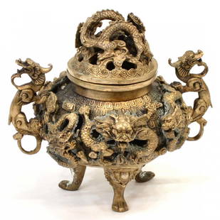 CHINESE BRONZE TRIPOD CENSER: Chinese bronze tripod censer, the squat body rising on three dragon mask-and-paw feet, the sides with apertures surmounted by four-clawed dragons in relief, each clutching flaming pearls, the pierced