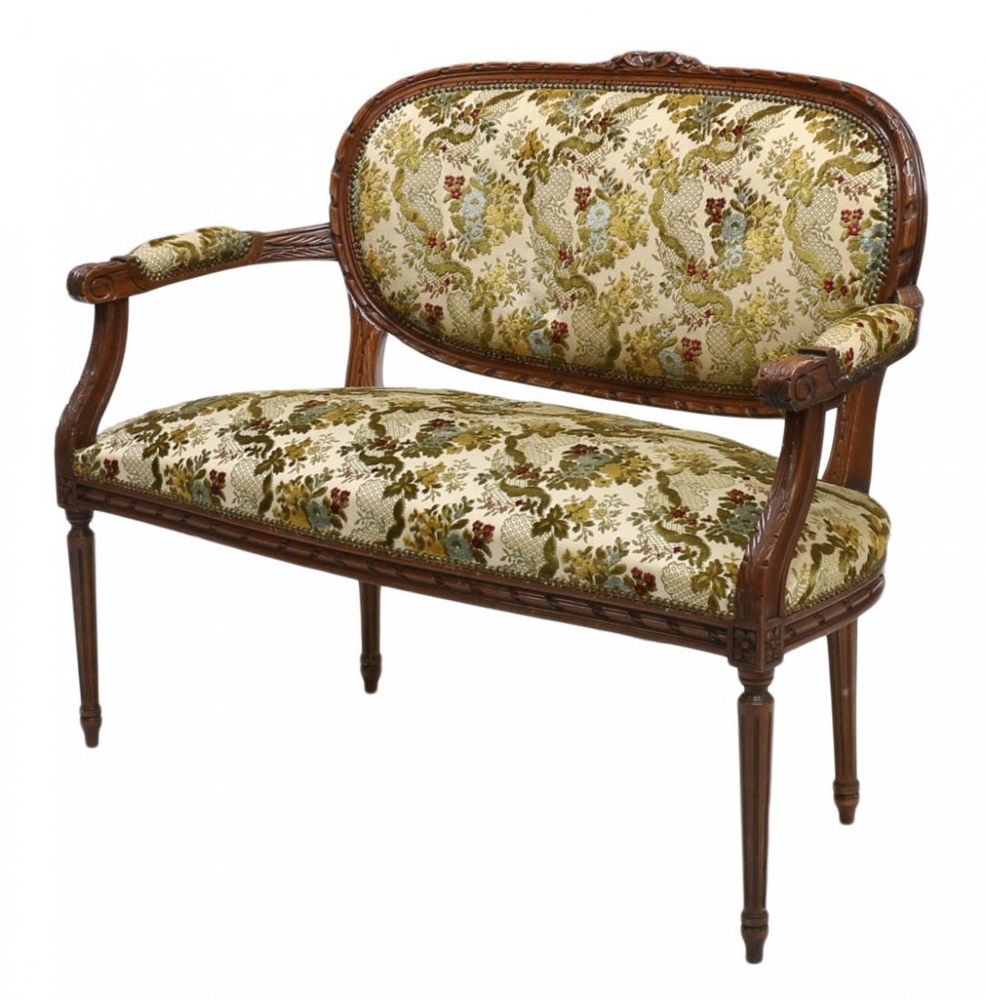 FRENCH LOUIS XVI STYLE SETTEE: French Louis XVI style settee, 20th c., having a floral carved crest rail over the upholstery appearing as cut velvet on silk, padded arms with scrolled handholds, rising on tapered ribbed legs, 39"h,